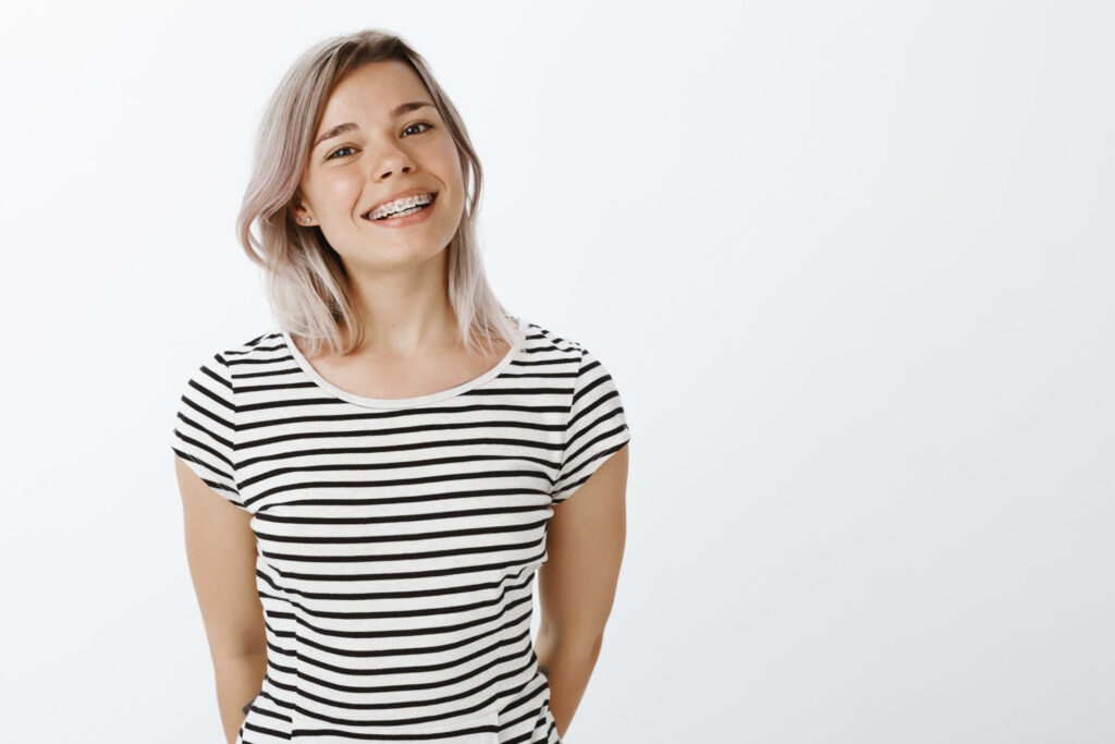 Young woman smiling with metal braces, one of the treatment options at Dr. Matt Orthodontics in Beaverton